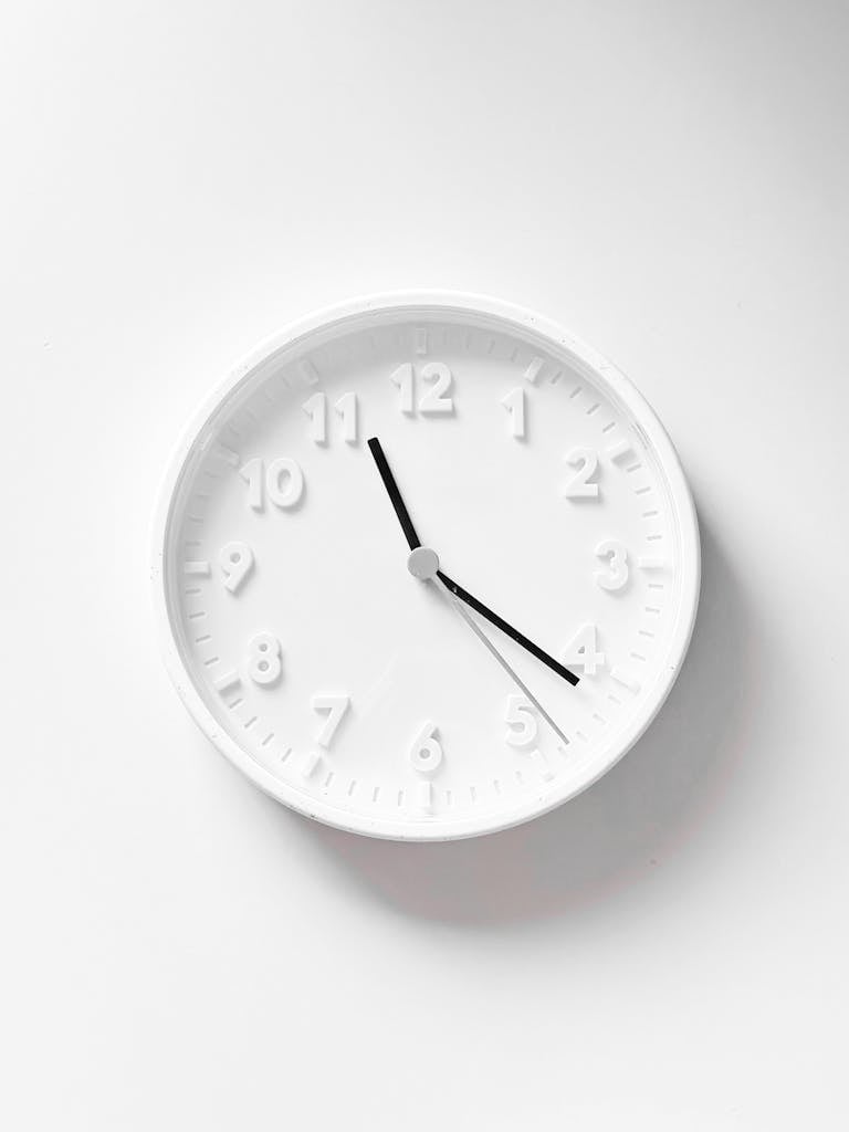 Simple and elegant white wall clock with minimalist design.